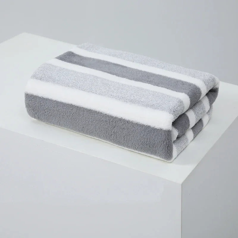 Gray and white striped bath towel folded on a white surface